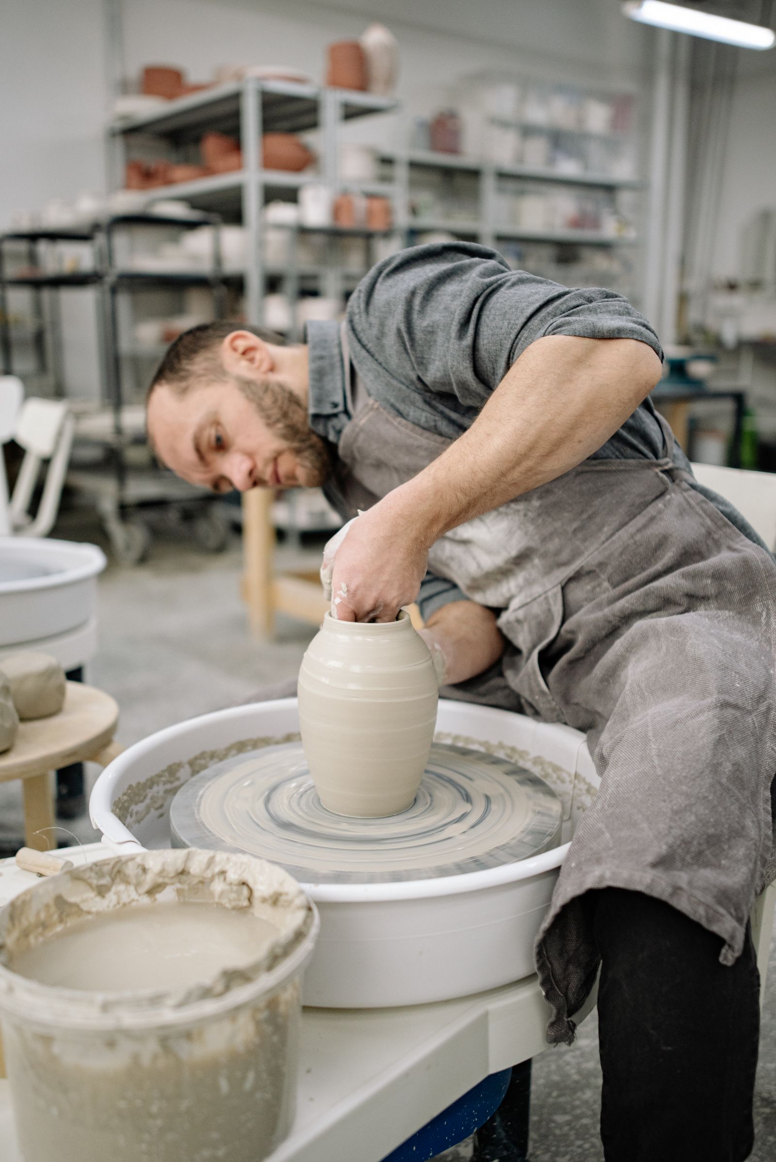 Maker working with clay in a bright workshop